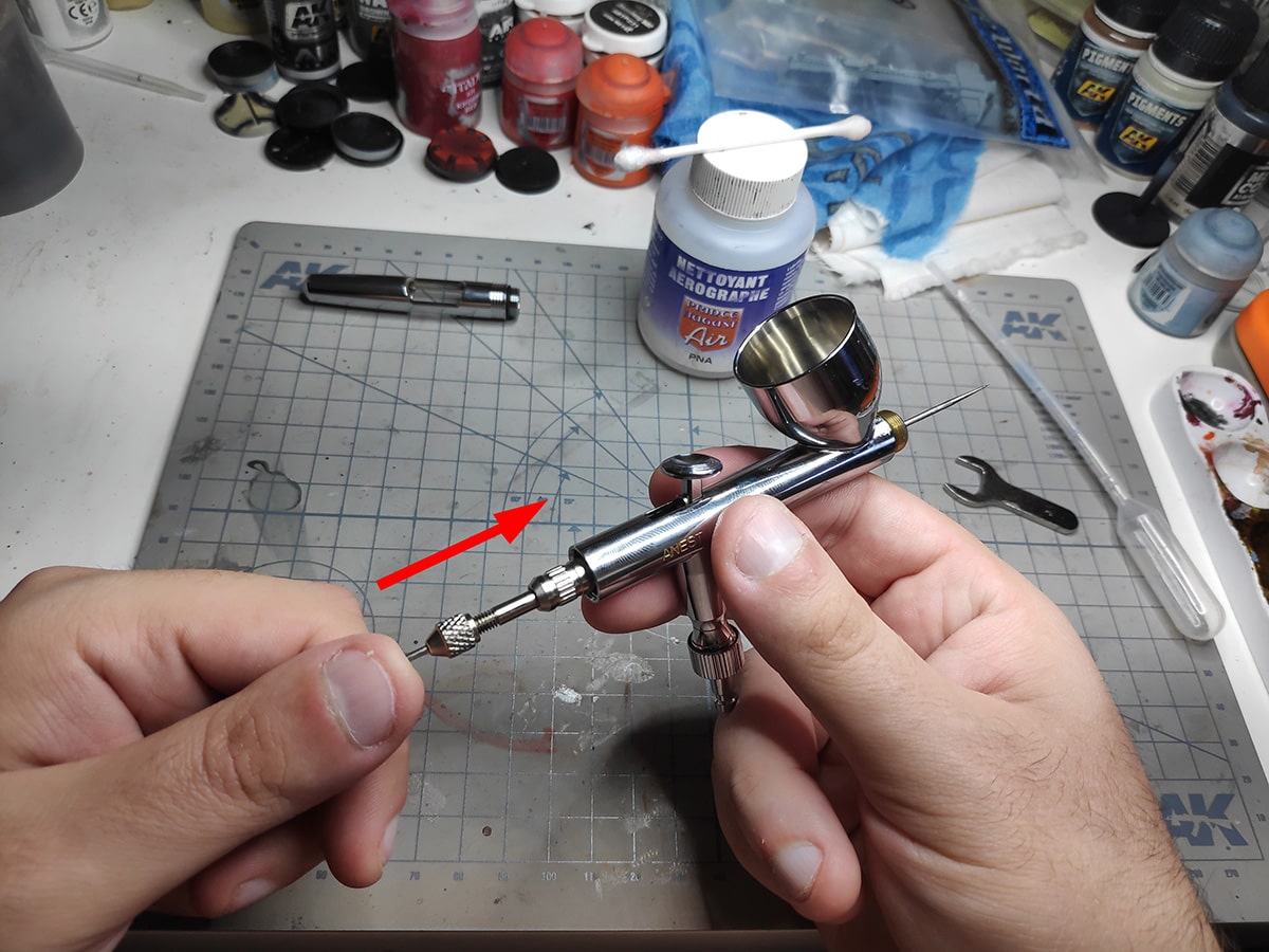 Push the needle out of the airbrush
